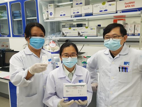 MP Biomedicals Diagnostics division's Research and Development team with their ASSURE(R) SARS-CoV-2 IgG/IgM Rapid Test kits. Two devices shown reflects positive IgG antibodies result (marked, on right) and a negative reading (unmarked, on left) From left: Ivy Teoh; Delynn Xu; Zee Hong Goh (Photo credit: MP Biomedicals)